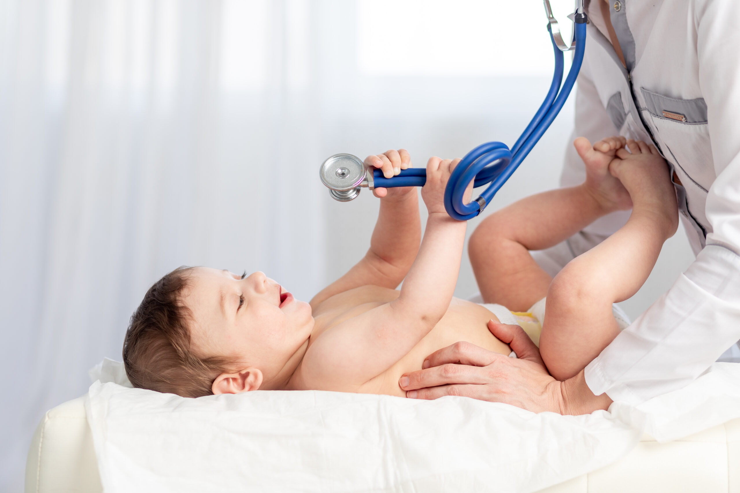 pediatrics, a doctor examines a baby boy and uses a stethoscope to listen to the child’s breathing, the concept of medicine and health