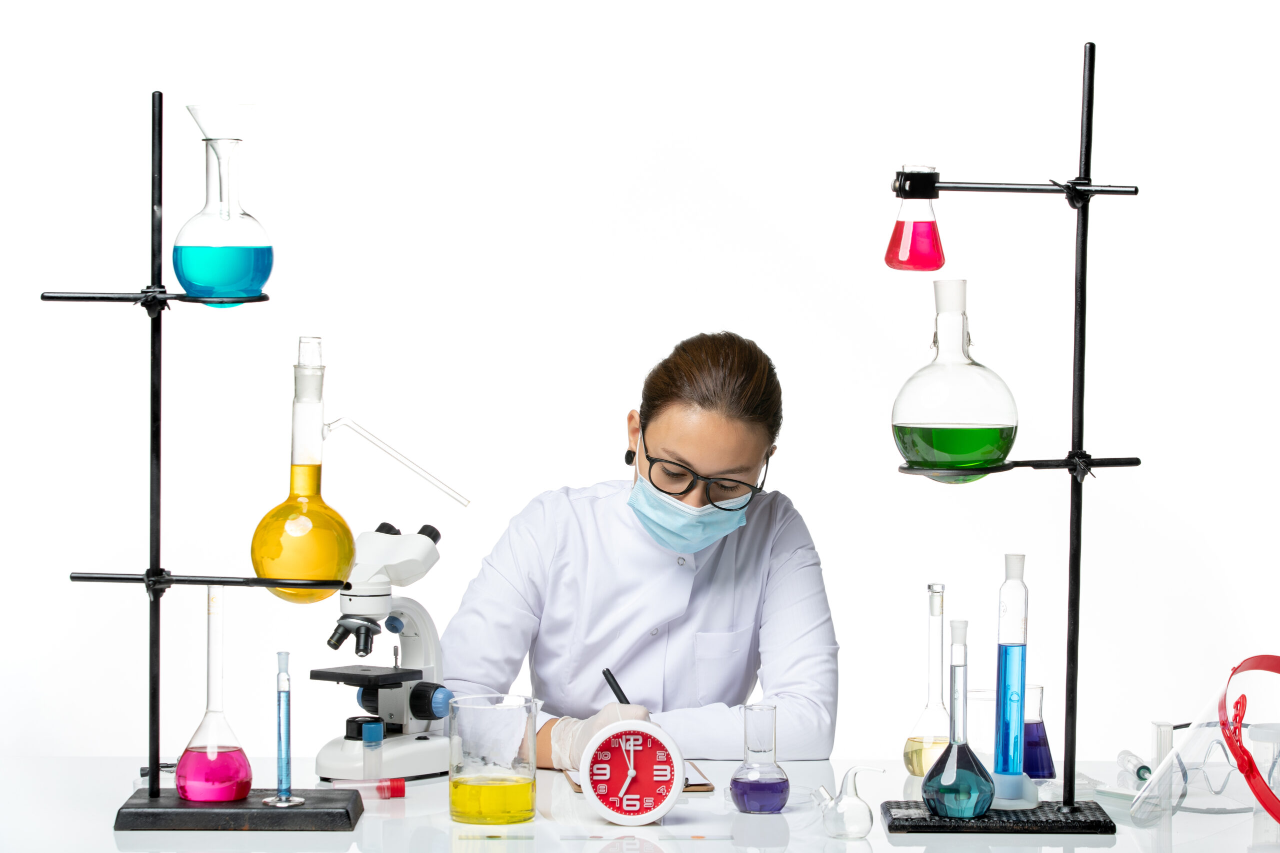 front-view-female-chemist-white-medical-suit-with-mask-sitting-with-solutions-writing-white-background-chemist-lab-virus-covid-splash